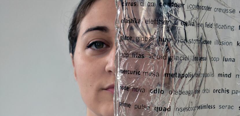 Artist's face behind a transparent page with black letters 
