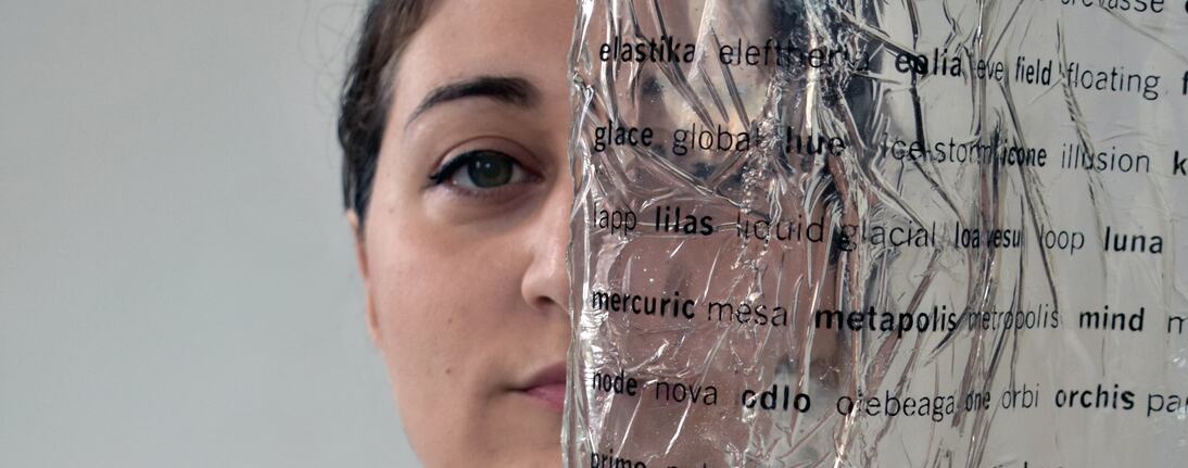 Artist's face behind a transparent page with black letters 