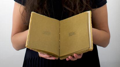 Person holding an open book in their hands 