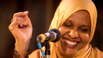 Asha Lul Mohamud Yusuf standing at a microphone, clicking her fingers.