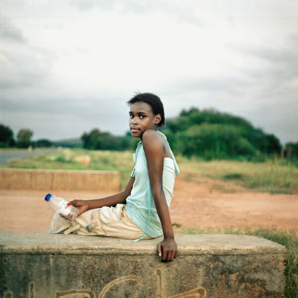 Homeland, Nklele Machika or Mary Koketse, Sehoko, former Bophuthatswana (2010) a photograph by Thabiso Sekgala depicting a young woman sitting on a concrete wall