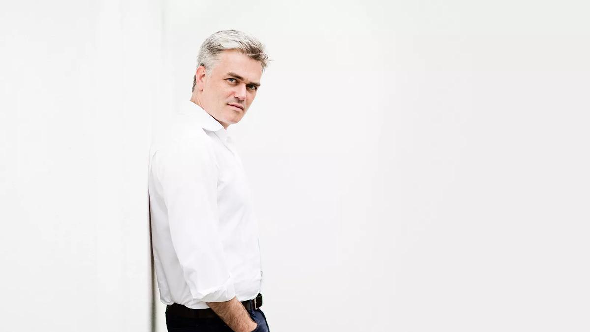 Conductor Edward Gardner in a white shirt standing against a white background
