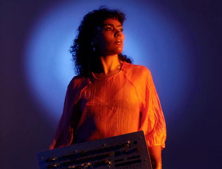 A woman holding a keyboard staring into the distance 
