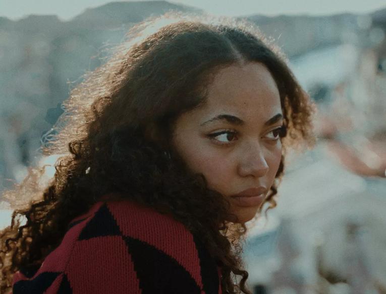 A woman with curly hair looking away from the camera 