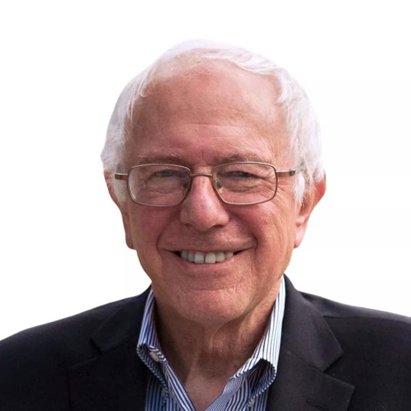 Bernie Sanders is an older white haired gentleman. He wears wire framed glasses and a black suit and smiles directly to camera. 