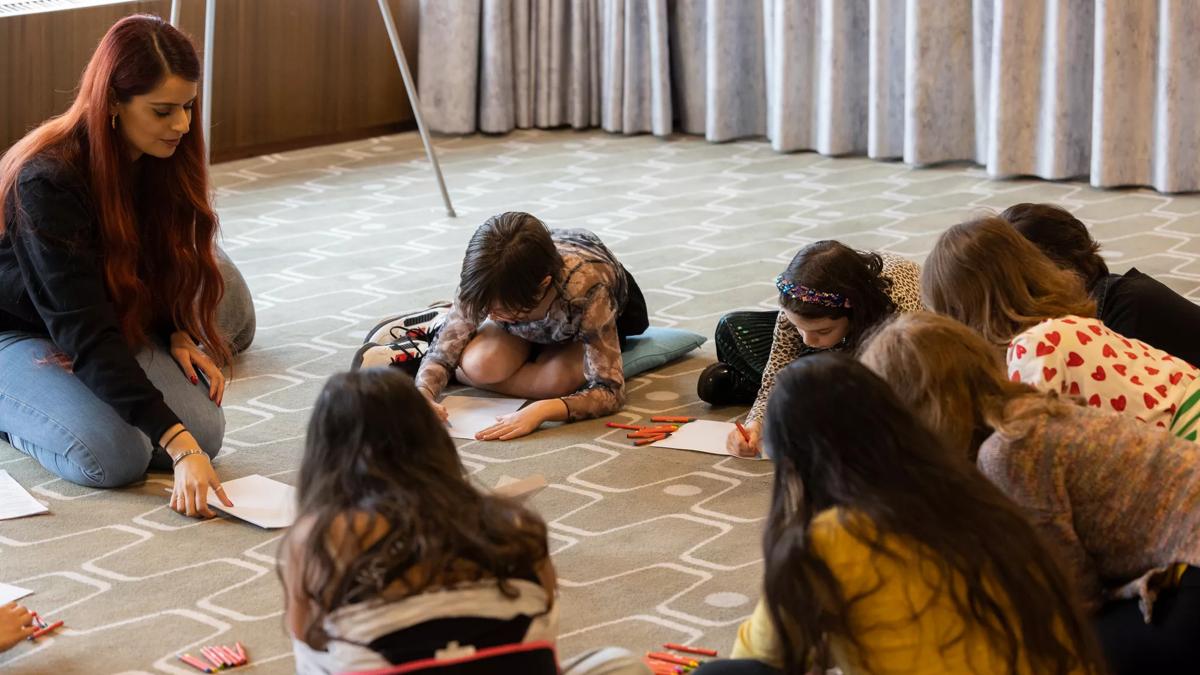 a group of girls of mixed ages participating in a workshop 