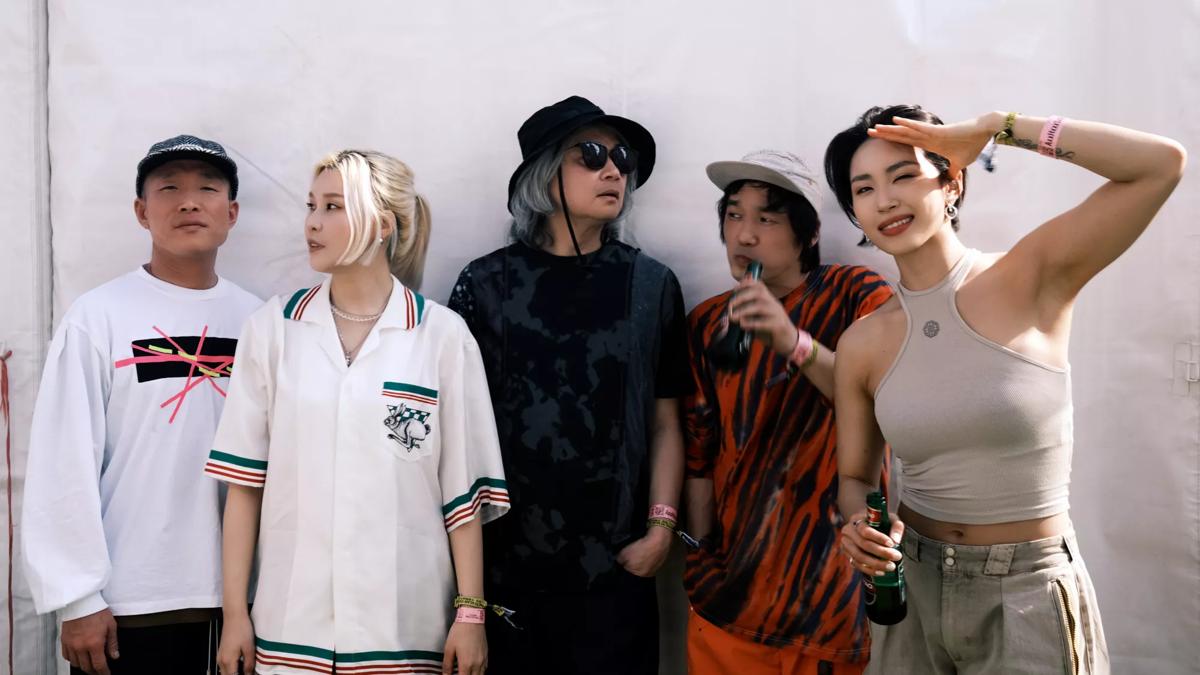 A group of five musicians wearing streetwear