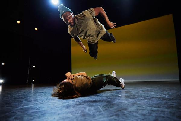 A dancer jumps over another dancer