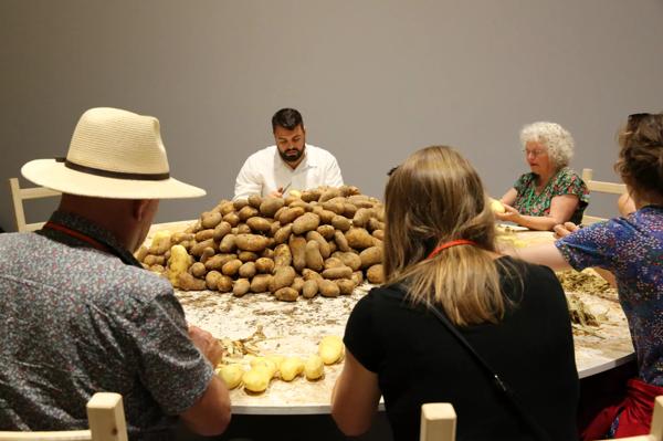 A group of people peeling potatoes