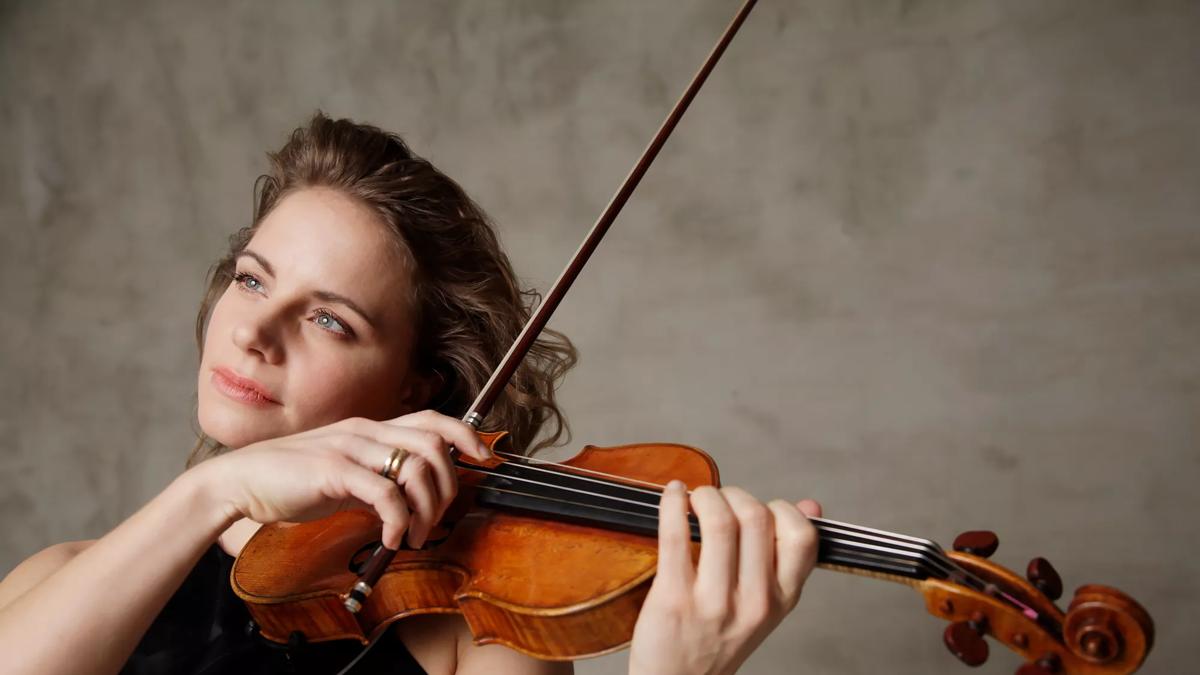 Violinist Julia Fischer playing a violin, looking up in the distance 