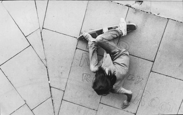 A vintage image of a skateboarder lying on the floor with their board at the Undercroft at the Southbank Centre