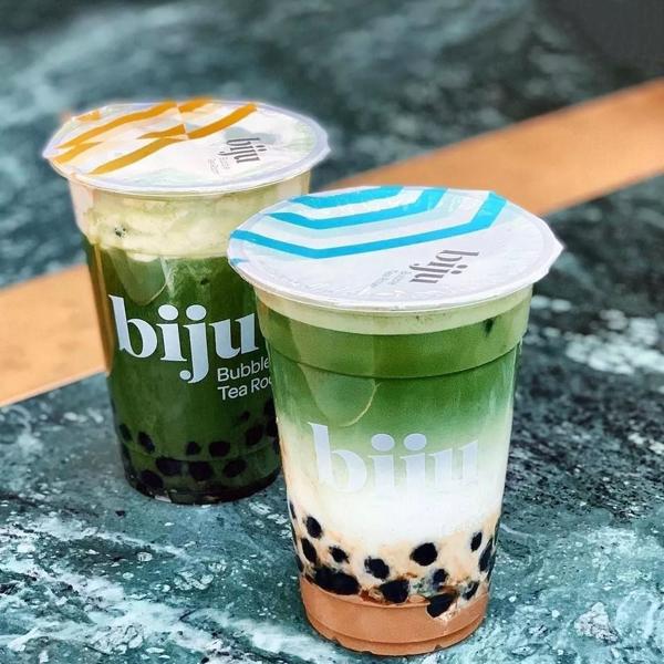 Two cups of greenbubble tea with biju logos on the cups