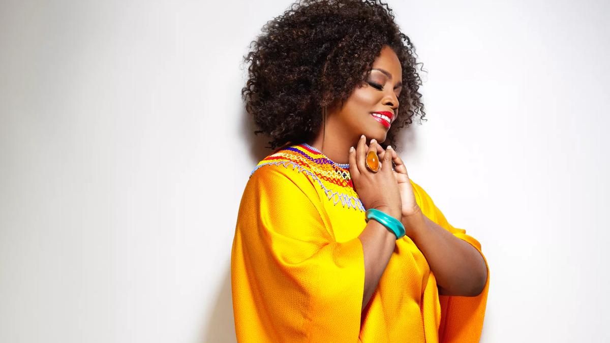 America Jazz Singer Dianne Reeves in a yellow silk outfit on a white background