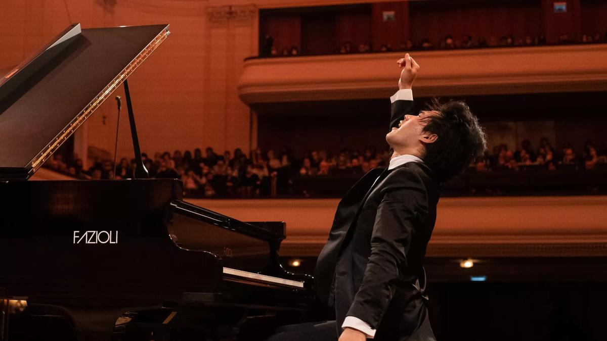 Bruce Liu playing a grand piano on stage