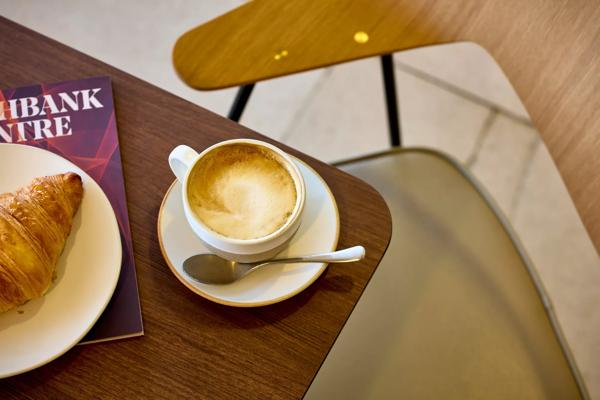 Coffee and croissant on table with chair