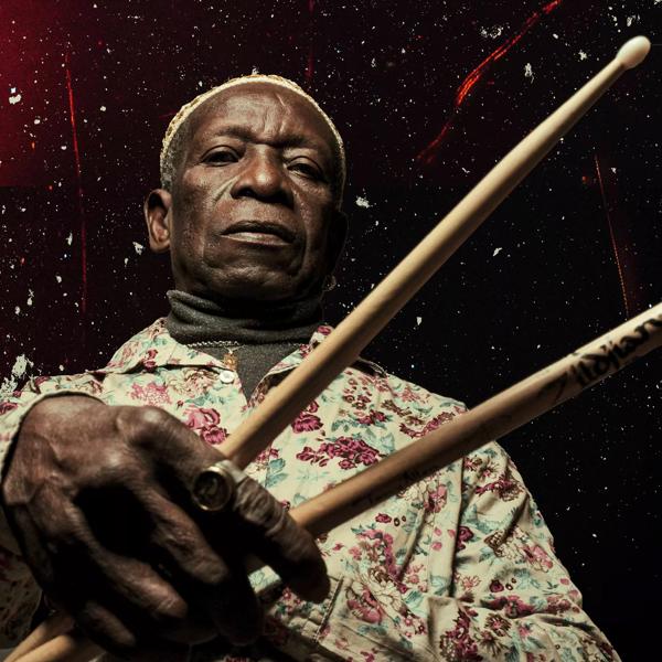 The late Tony Allen holding drumsticks 