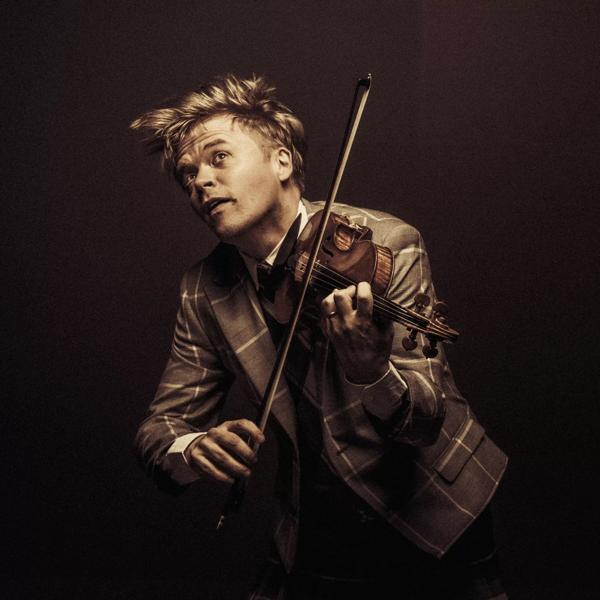 Pekka Kuusisto playing the violin in a checkered suit