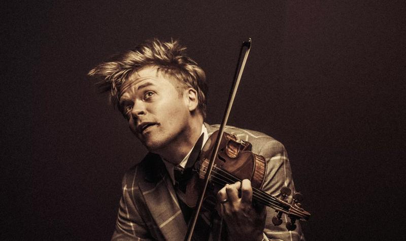 Pekka Kuusisto playing the violin in a checkered suit