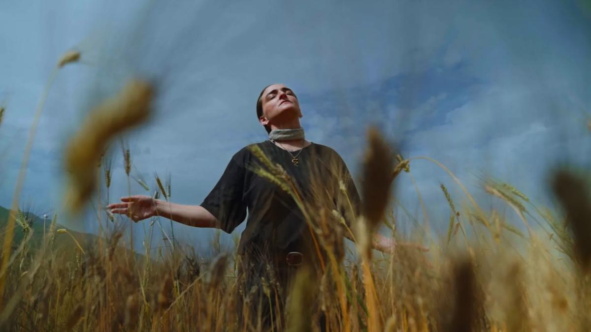 A woman standing in a field of wheat