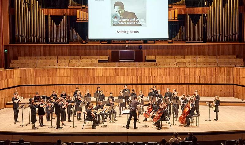 Young musicians perform as an orchestra on the stage of the Royal Festival Hall