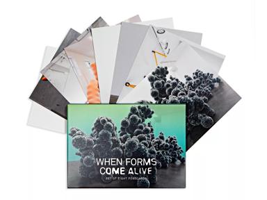 Photo of the exhibition postcard pack, with the cards displayed as a fan out of the packaging