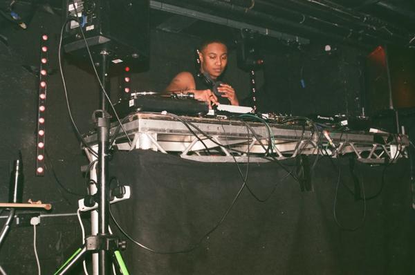 Photo of the DJ Rabz in front of decks with headphones round their neck. 