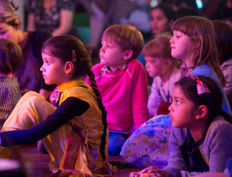 Children watching an event in the audience.