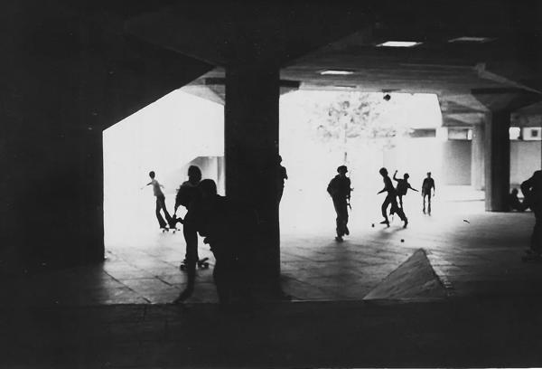 A vintage image of a skateboarders in action at the Undercroft at the Southbank Centre, the skateboarders are silhouetted by the light coming into the space from behind them