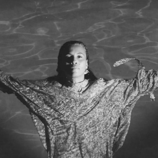 Neneh Cherry floating in a swimming pool 
