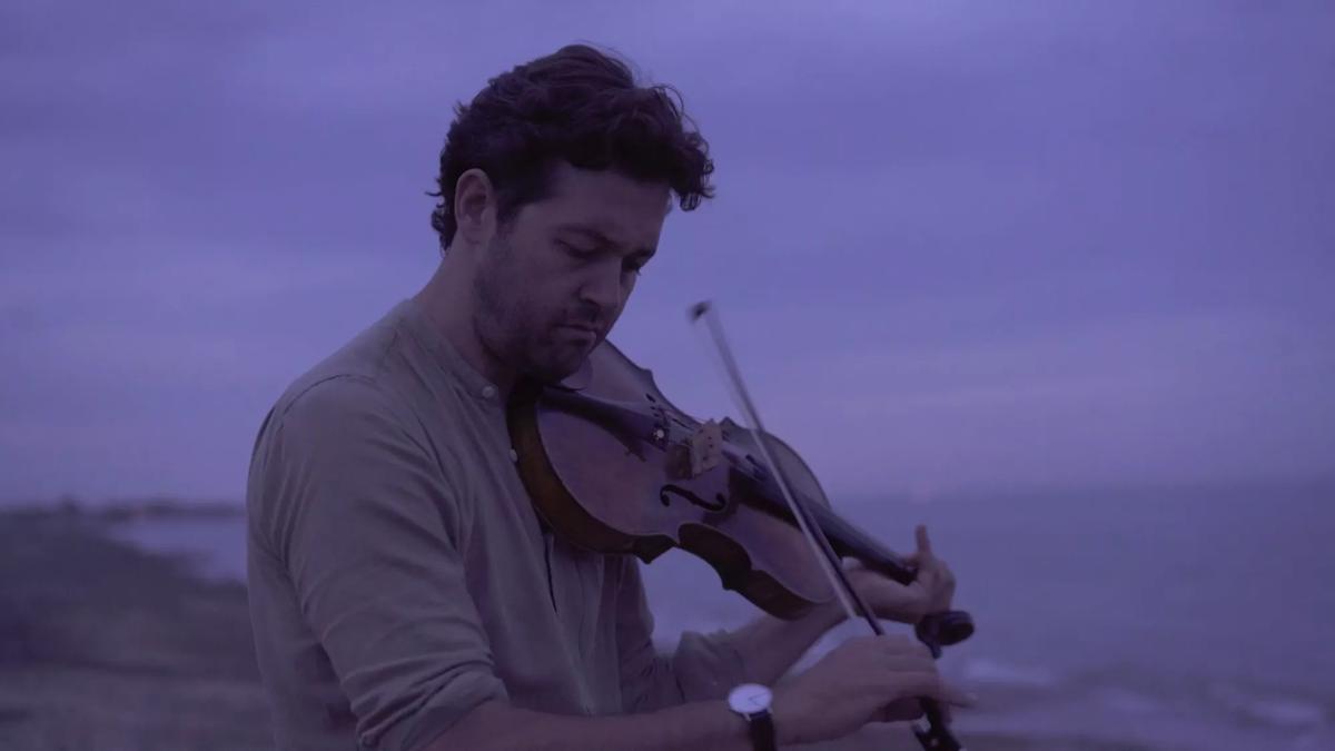 Lawrence Power playing the violin next to the ocean