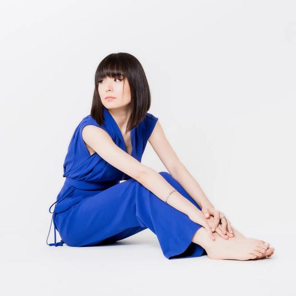 Alice Sara Ott  sat on the floor in a blue jumpsuit