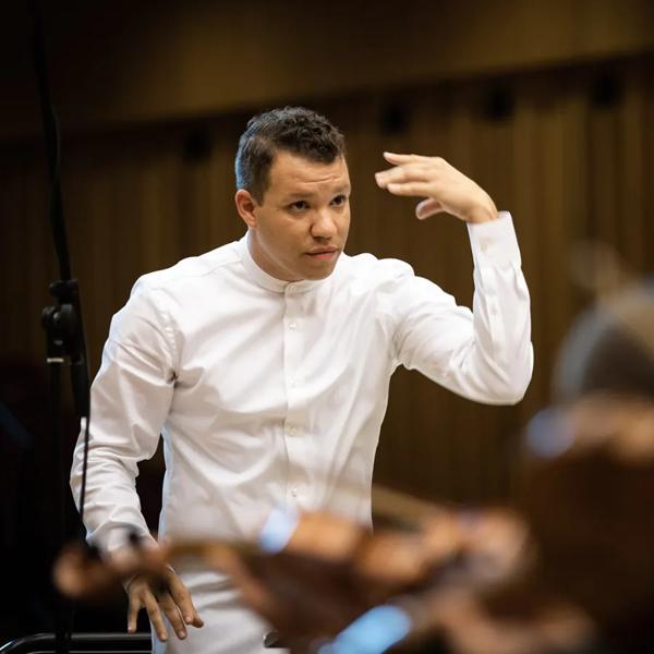 Candid portrait of Ryan Bancroft conducting an orchestra