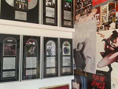 Vinyl record frames cover the left hand of the wall and on the right  album cover posters