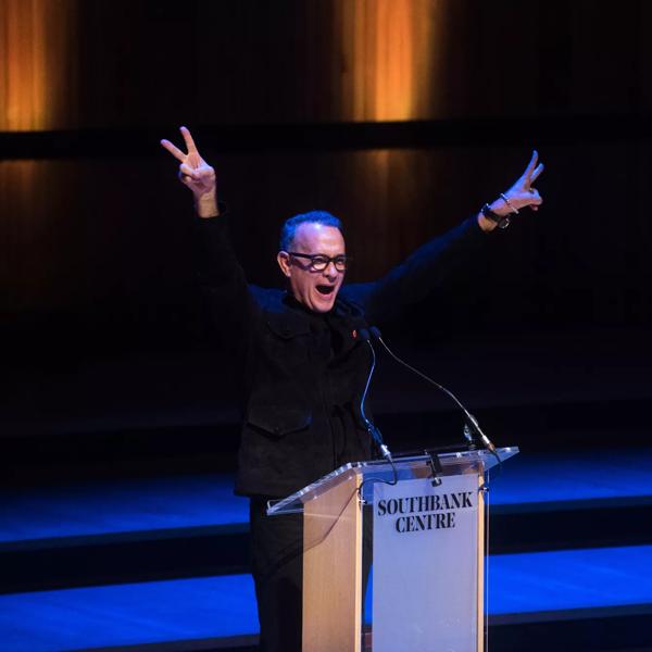 Tom Hanks doing peace signs on stage