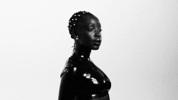 A woman photographed in black and white with beads in her braids