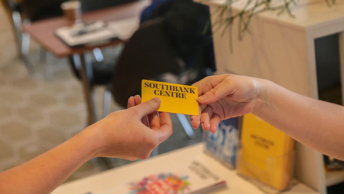 Two hands exchanging Southbank Centre membership card at the Southbank Centre Members Bar