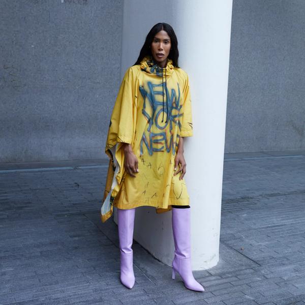 Musician and DJ Honey Dijon in a yellow coat with New York imprinted on it