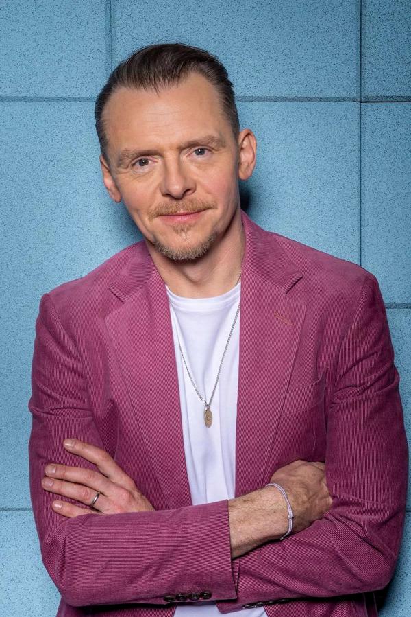 Simon Pegg wearing a pink suit blazer and a white t shirt