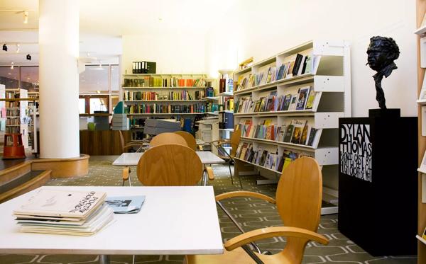 The interior of the National Poetry Library including a table, a bust of Dylan Thomas and several anthologies and collections on book shelves