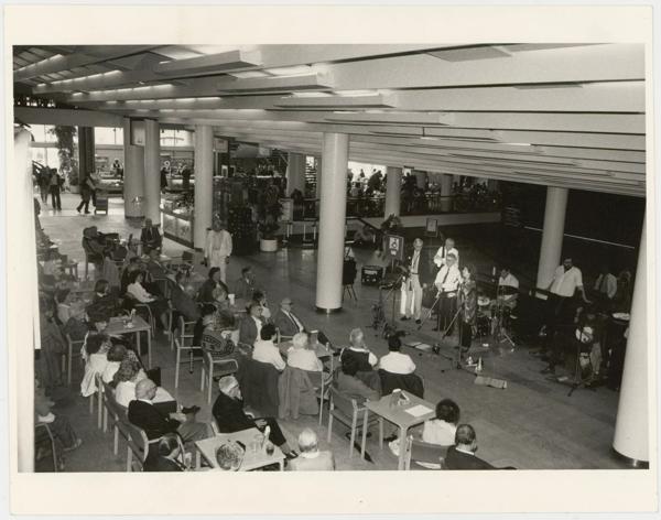 A live music event in the Royal Festival Hall in the late 1980s/early 1990s – musicians perform on the edge of the Clore Ballroom as an audience seated around tables watches on
