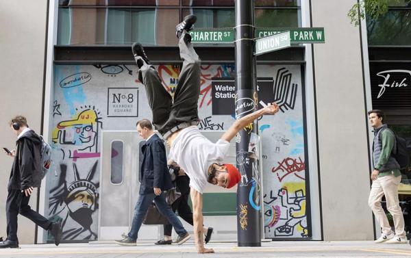 Dancer Chilly does a one handed handstand on a pavement in New York.