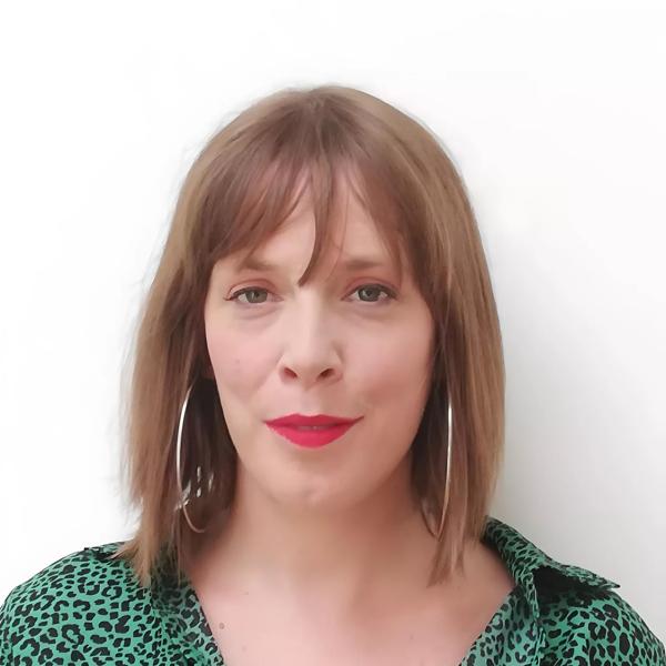 Jess Phillips wears a green shirt and silver earrings