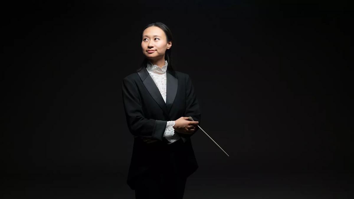 Conductor Tianyi Lu against a black backdrop