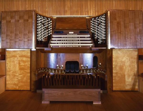 An archive image of the console of the Royal Festival Hall organ; it is a varnished wooden structure; its many pedals, stops and keys are all visible