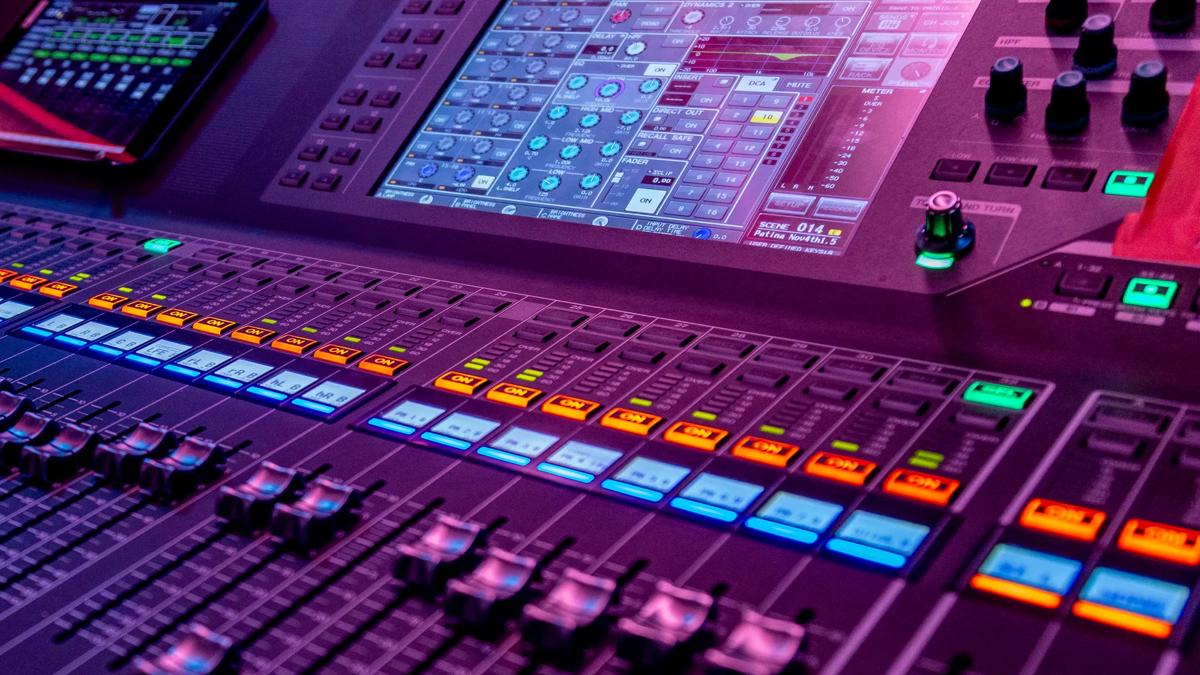 A. close up shot of an audio mixing desk with many faders and buttons