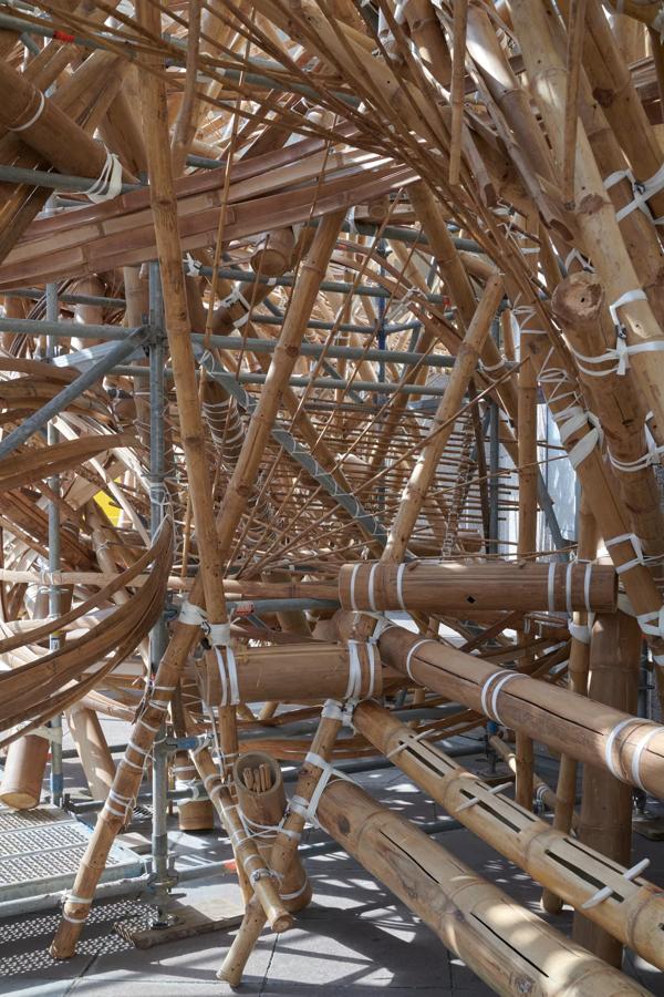 An inside view of a bamboo structure held up by metal scaffolding