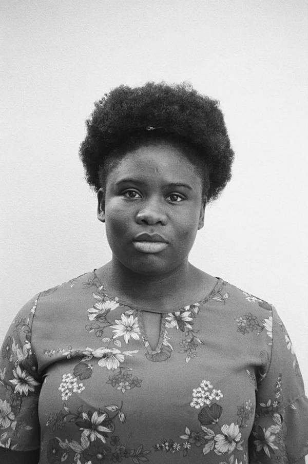 A portrait of Grace Olanma Etigwe-Uwa, taken against a light concrete wall
