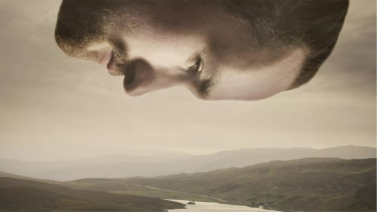 Fergus McCreadie's face hanging over a landscape of rolling hills 