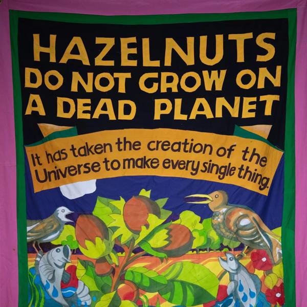 A banner with the phrase 'Hazelnuts do not grow on a dead planet' and a hazel branch with fish and birds around it