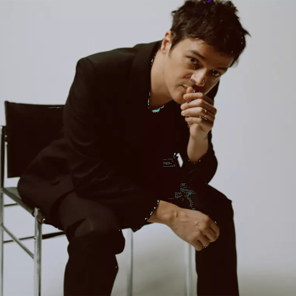 Jamie Cullum sits on a chair against a white background